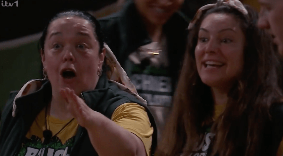 Two women watching an event with surprised expressions.