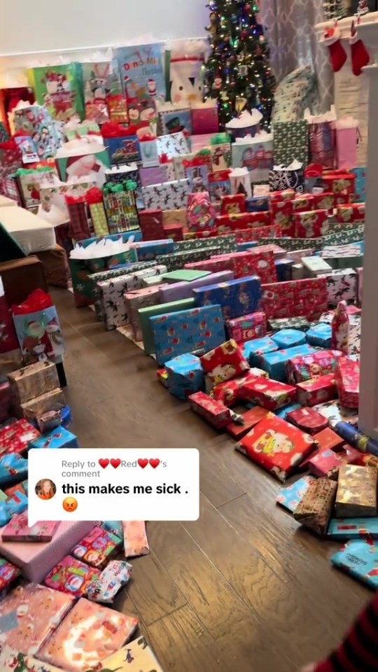Numerous wrapped Christmas gifts covering the floor, with a Christmas tree in the background.