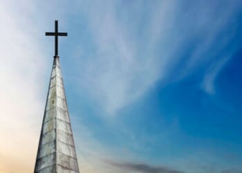 A cross and a church steeple stand still.