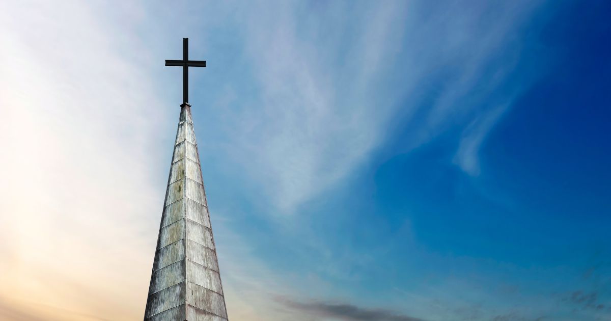 A cross and a church steeple stand still.