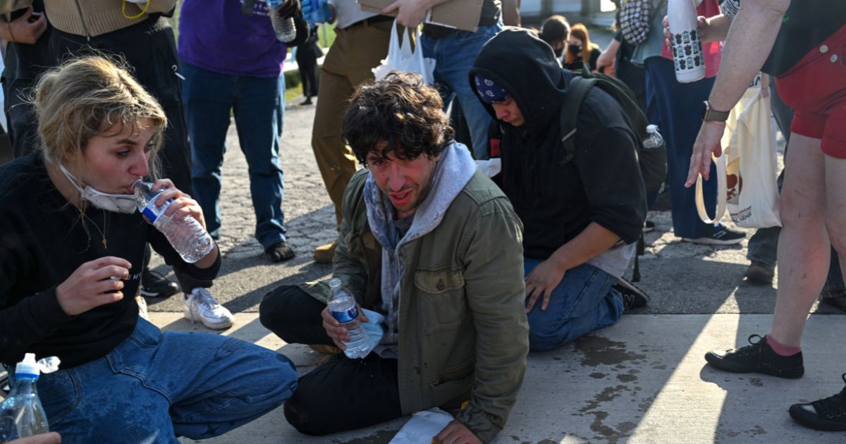 Demonstrators protesting outside the U.S Immigration and Customs Enforcement facility, including Democratic congressional candidate Kat Abughazaleh, 26, left, react after being tear-gassed on Sept. 19, 2025, in Broadview, Illinois.