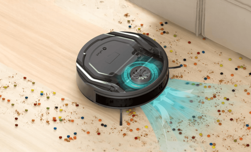 Lefant robot vacuum cleaning a wooden floor with dirt and colorful pellets.