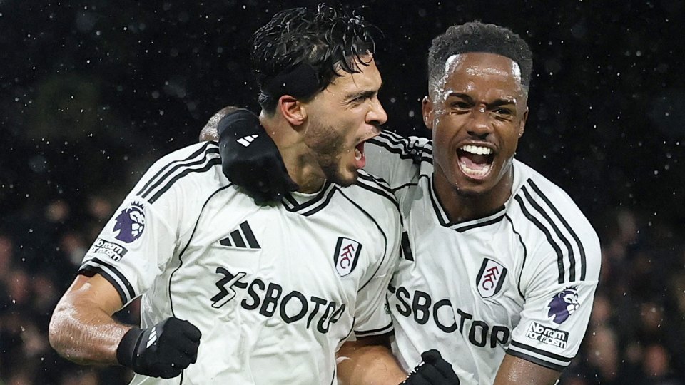 Two Fulham soccer players celebrate a goal.