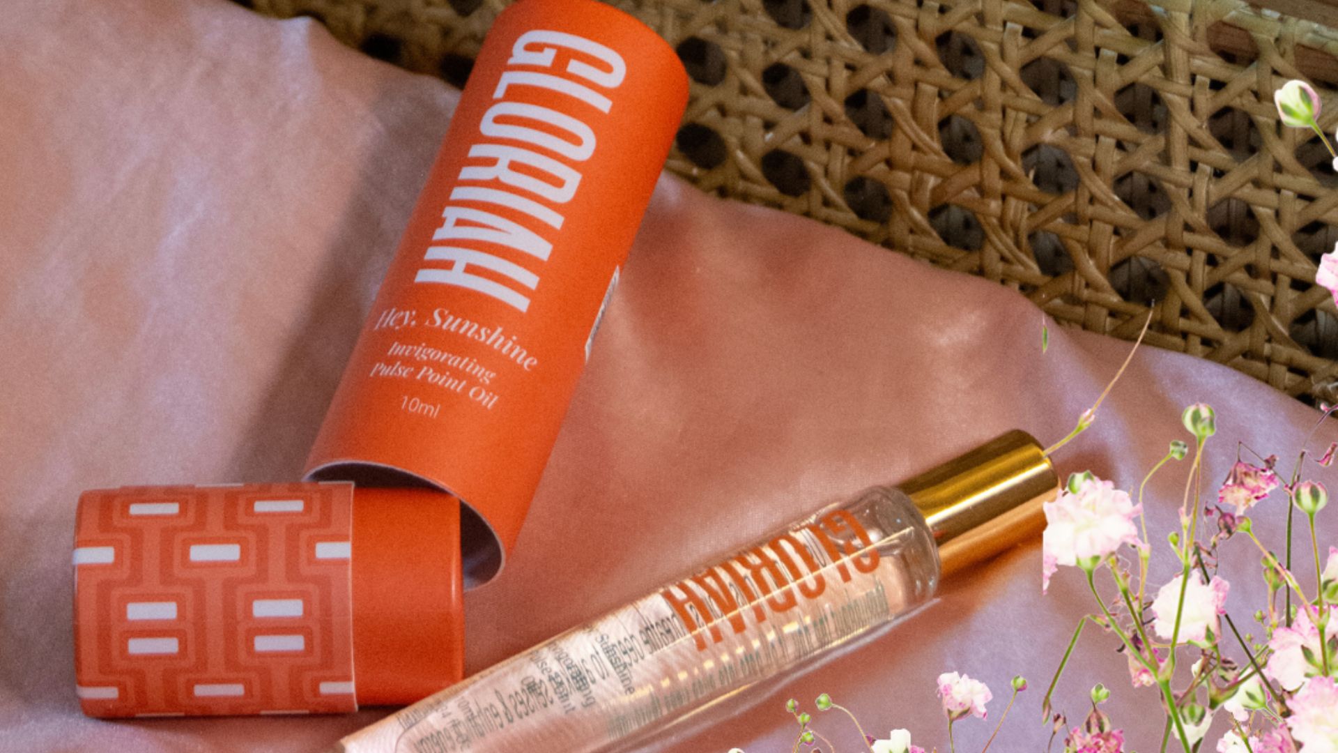 Gloriah Hey, Sunshine Invigorating Pulse Point Oil with its packaging on a pink cloth.