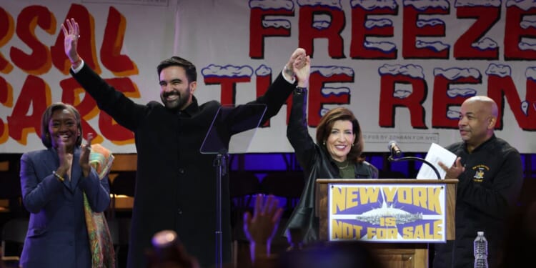 New York City Mayor-elect Zohran Mamdani holds hands with New York Gov. Kathy Hochul on stage during a campaign rally at Forest Hills Stadium in the Queens borough of New York City on Oct. 26, 2025.