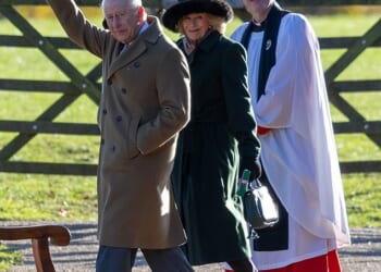 King Charles wrapped up warm, placing his hands inside his brown double-breasted overcoat, which he paired with grey suit trousers and taupe coloured loafers