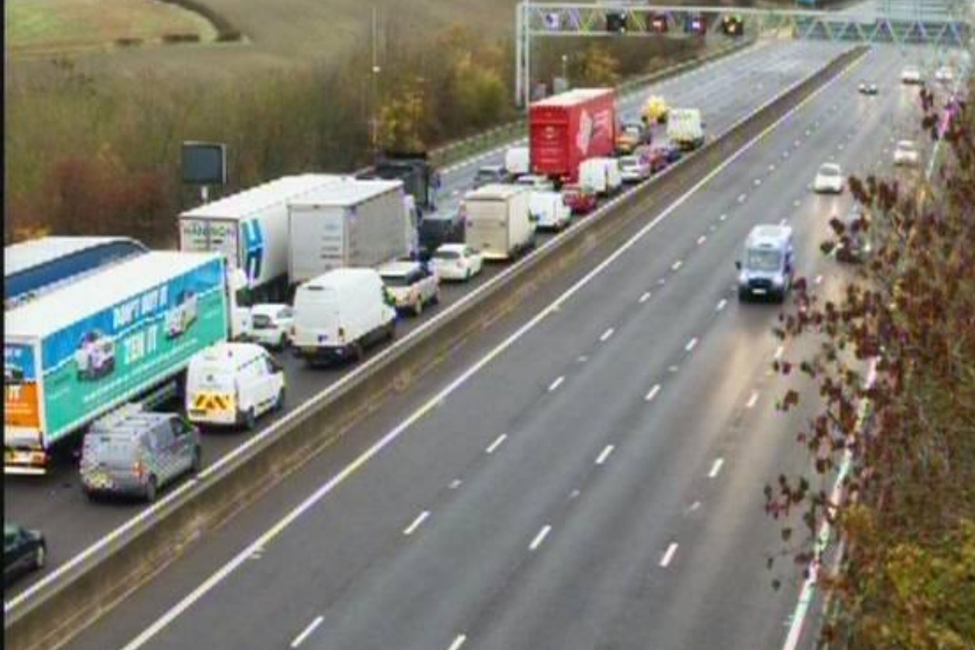 An image collage containing 1 images, Image 1 shows Traffic jam on the left lanes of a multi-lane highway, with cars moving on the right lanes