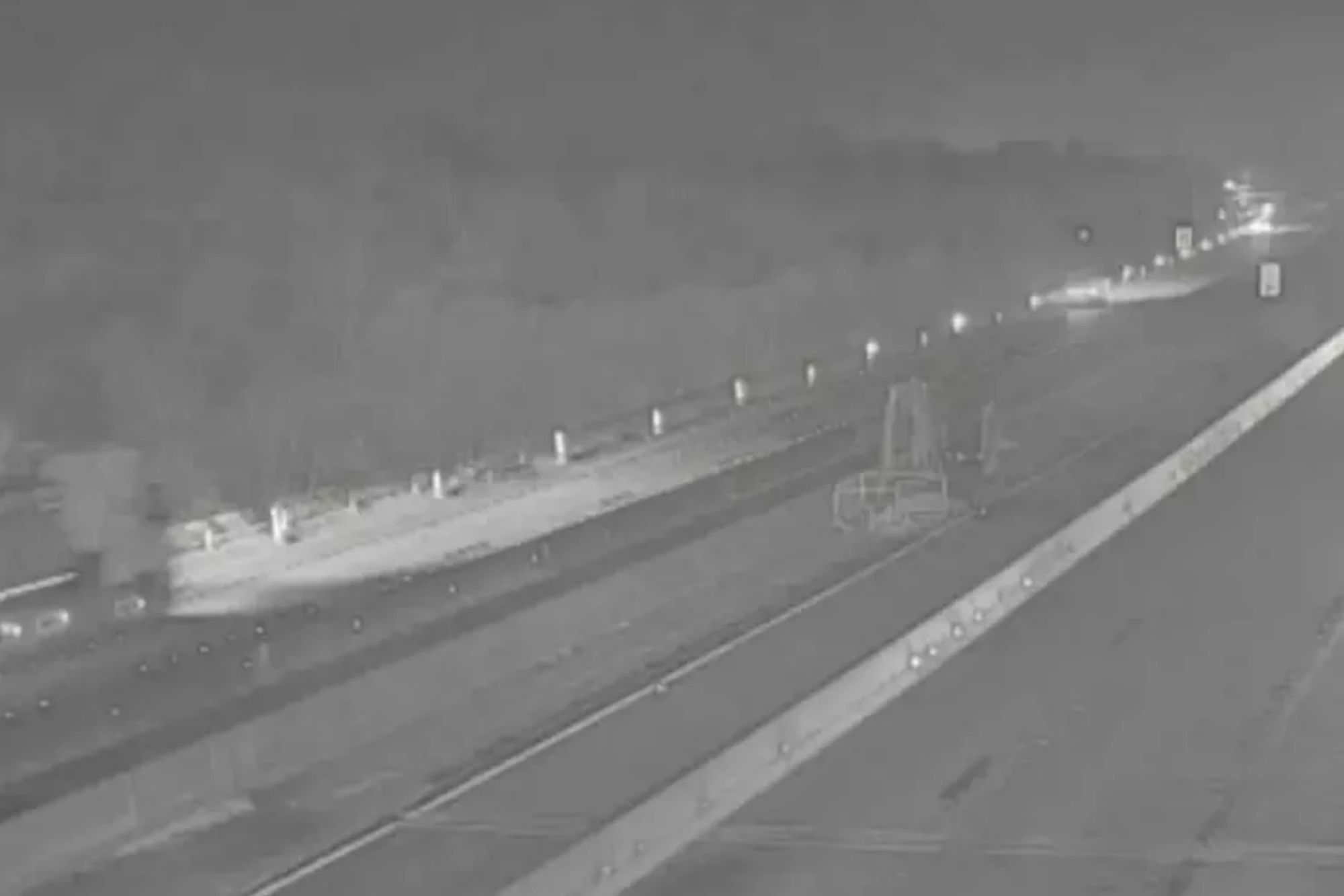 An image collage containing 1 images, Image 1 shows A multi-lane highway at night with a large vehicle on the left emitting smoke