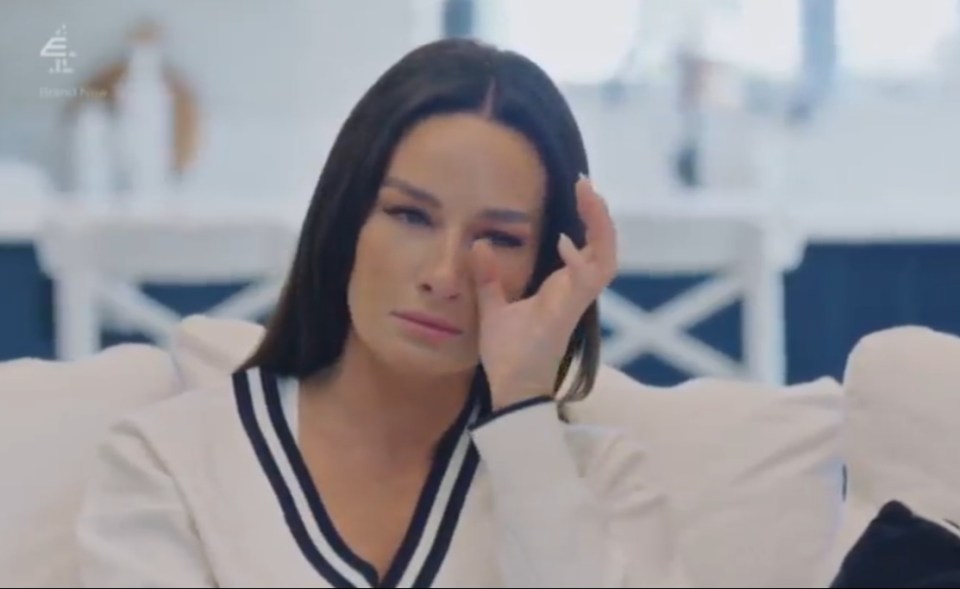 A woman wiping away tears from her face.