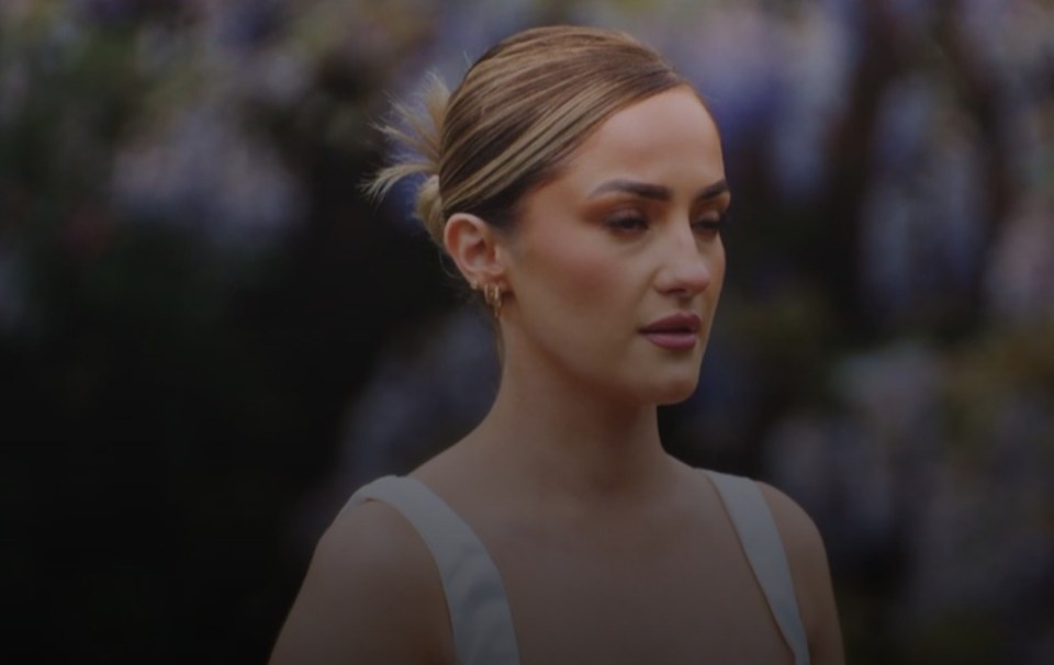 Woman with a neutral expression and light brown hair pulled back in a ponytail.