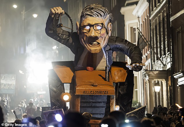 An effigy at Lewes Bonfire Night last night showed a crazed-looking Sir Keir, complete with glowing, bright eyes and disheveled glasses, as he rides a tractor with 'all lies Starmer' written on the front