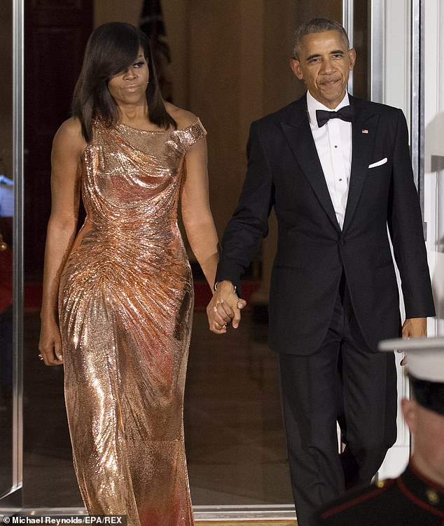 Michelle, pictured with husband Barack Obama in 2016, claimed that Black women are 'trapped' by the pressures to keep their hair straight and 'can't swim' or 'go to the gym'