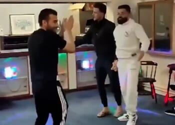 The Kurdish men can be seen dancing in a disco area with flashing lights and a sound system