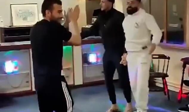 The Kurdish men can be seen dancing in a disco area with flashing lights and a sound system