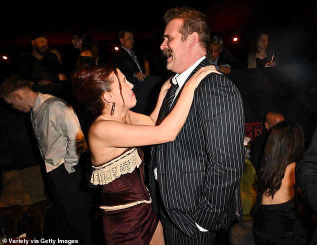 Despite reports Millie has filed a harassment and bullying claim against David, she was pictured with her hands on his shoulders as she laughed hysterically at his jokes