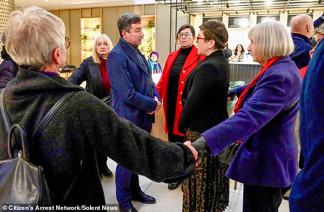 Footage shows businessman Lawrence Gosden surrounded by hand-holding anti-pollution protesters as he makes his way to a conference in London