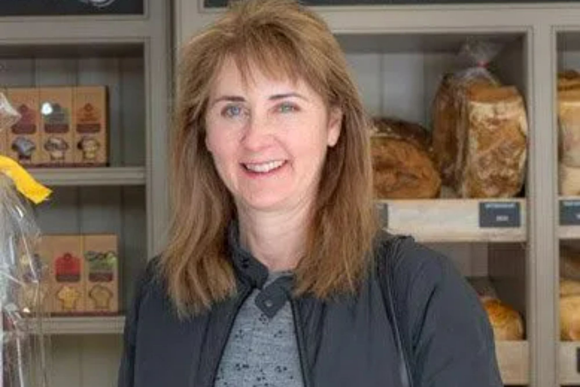 An image collage containing 1 images, Image 1 shows A smiling woman with light brown hair and a dark jacket in a bakery