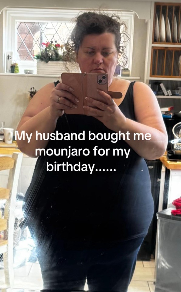 A woman in black clothes taking a mirror selfie.