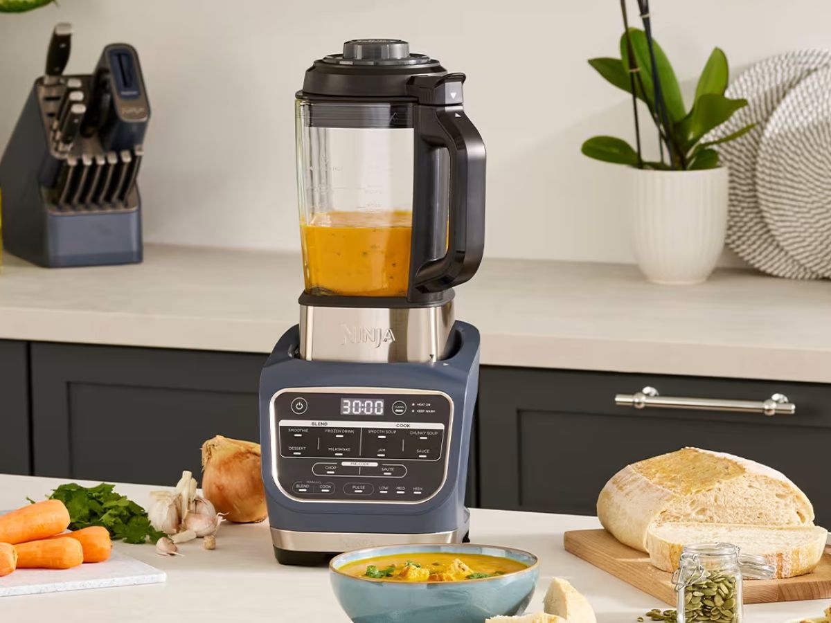 A Ninja Foodi Power Blender & Processor System on a kitchen counter with ingredients.