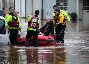 Emergency services help people stricken on a flooded street on November 15 in Monmouth, Wales