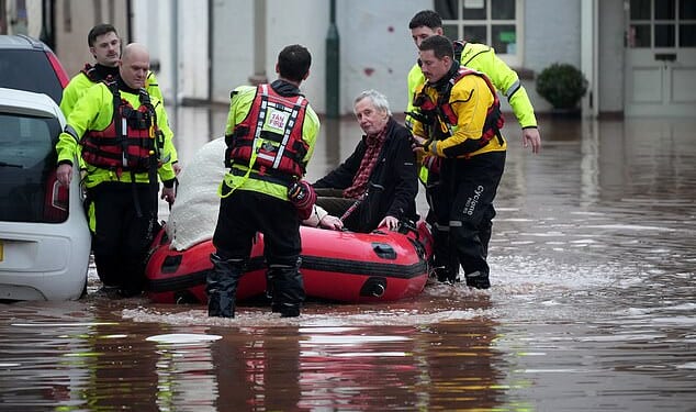 Emergency services help people stricken on a flooded street on November 15 in Monmouth, Wales
