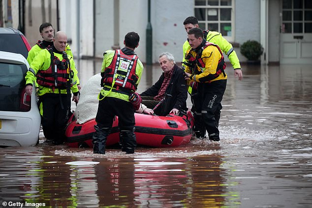 Emergency services help people stricken on a flooded street on November 15 in Monmouth, Wales