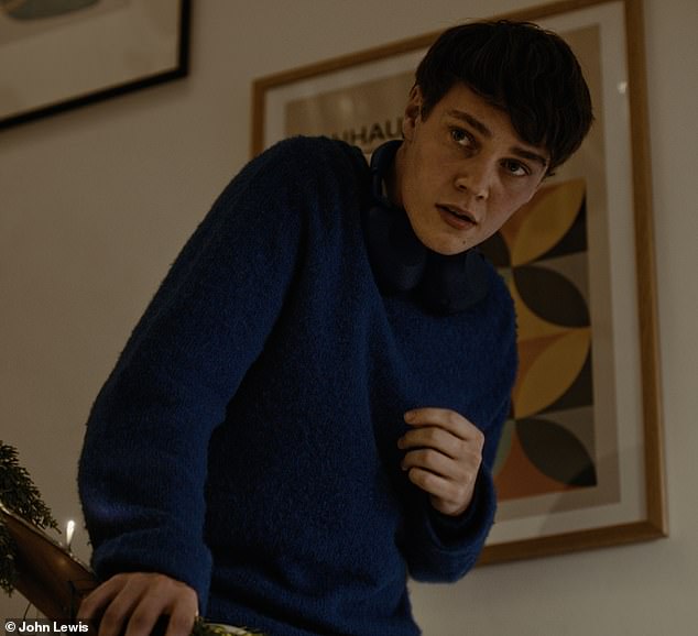 His teen (pictured) - with headphones clamped around his neck - timidly watches his father's reaction