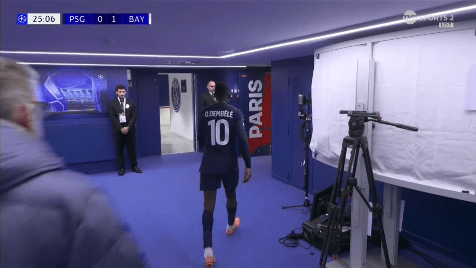 Soccer player O. Dembélé walks through a blue hallway.