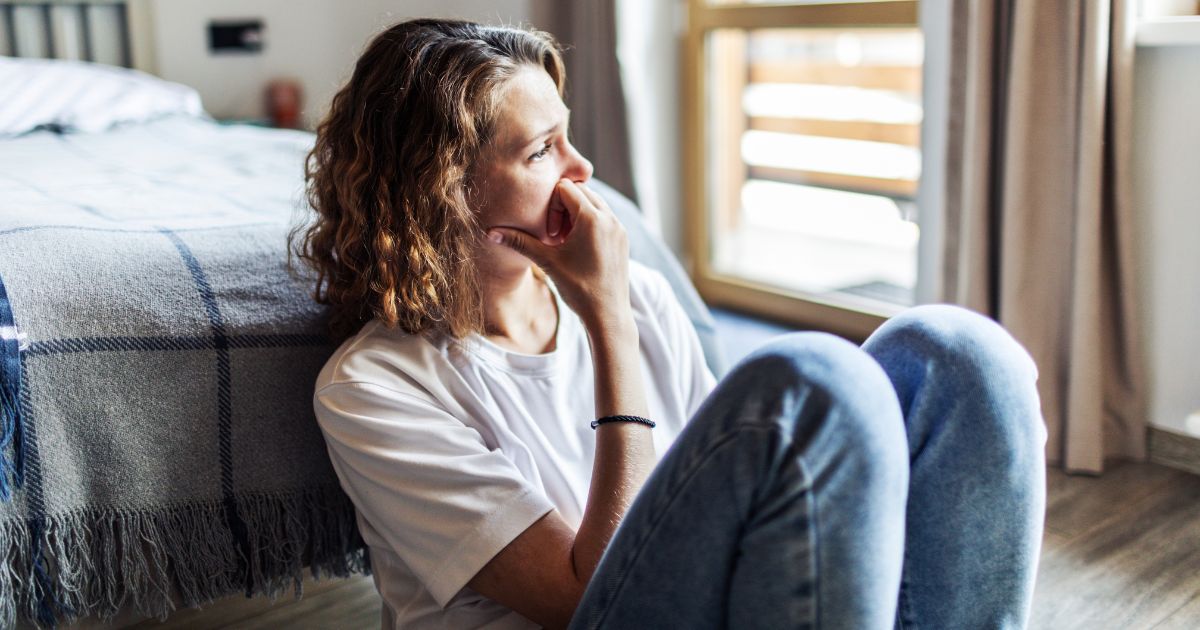 A young woman sits alone.