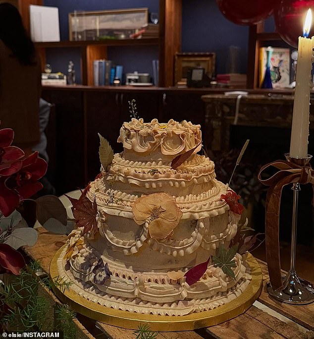 A variety of leaves were scattered on each tier of the cake which contained additional, intricate frosting on the sides