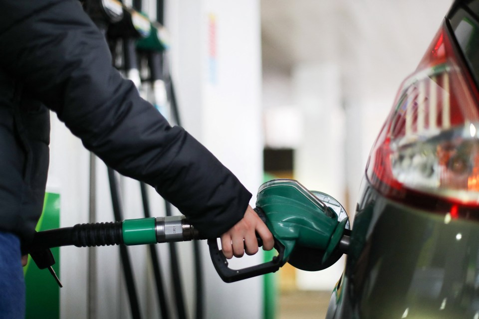 A person refuels their car with petrol at a London filling station.