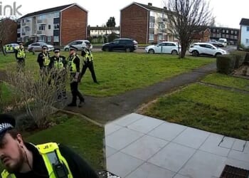 CCTV shows six uniformed police officers descending on their suburban home before they were led away in front of their crying daughter in January
