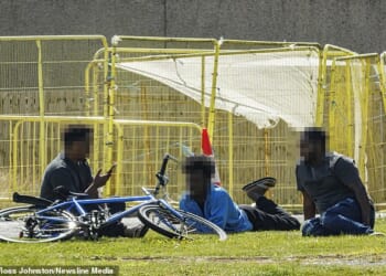 Police have launched a probe after a man was attacked at a hotel that has been used to house asylum seekers in Aberdeen. Pictured: Men sit on the ground at one of the migrant hotels in Aberdeen