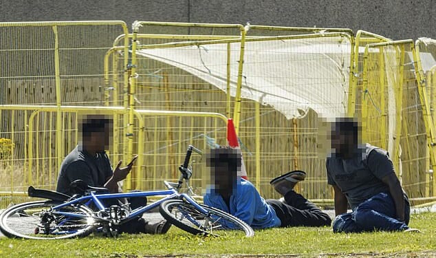 Police have launched a probe after a man was attacked at a hotel that has been used to house asylum seekers in Aberdeen. Pictured: Men sit on the ground at one of the migrant hotels in Aberdeen