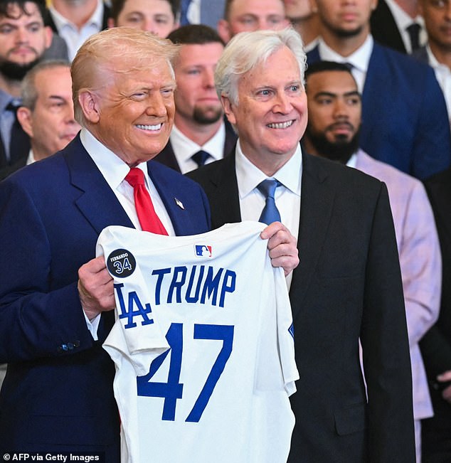 US President Donald Trump holds up a Dodgers jersey alongside team owner Mark Walter in the Oval Office in April