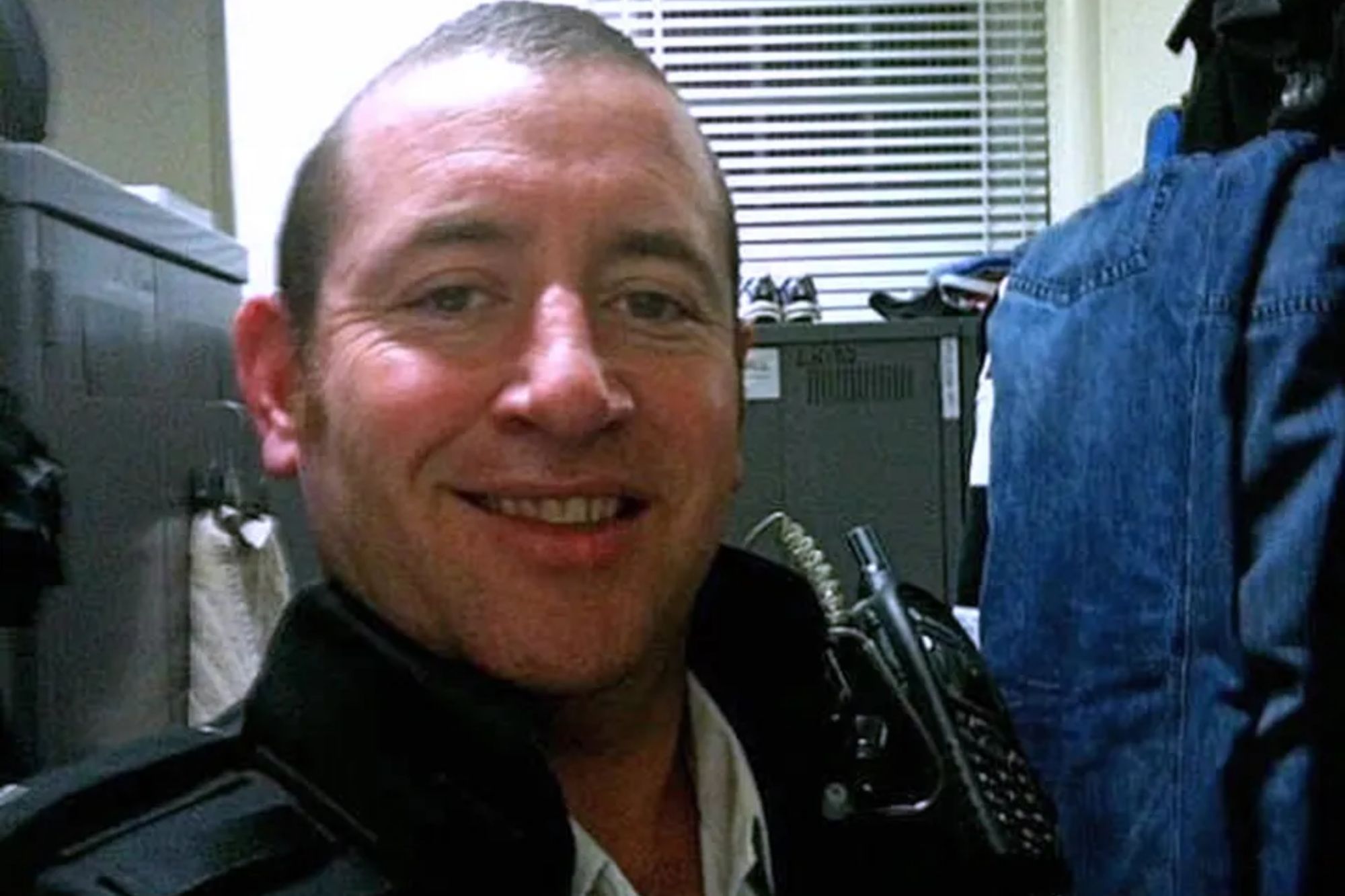 An image collage containing 1 images, Image 1 shows A man in a police vest smiling at the camera