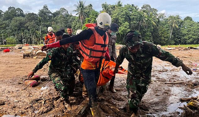 Rescuers carry a person through the flood-devastated region of West Sumatra, Indonesia, on Sunday amid an urgent search for hundreds of missing individuals