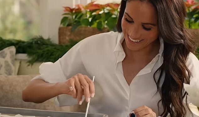 Pictured: Meghan smiling while painting snowflake cookies for Archie and Lilibet