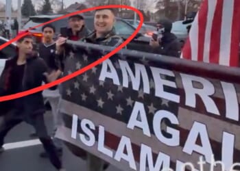 The young man winds up to hit Jake Lang during the "Americans Against Islamification" march in Dearborn, Michigan.