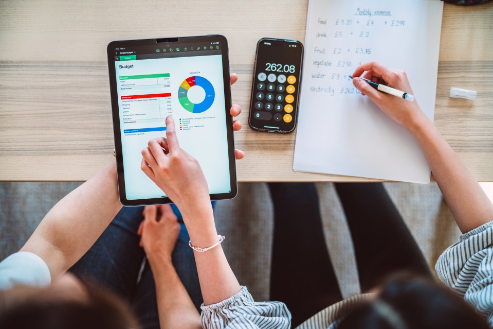 Directly above shot of young Asian mother and teenage daughter learning finance together at home.
