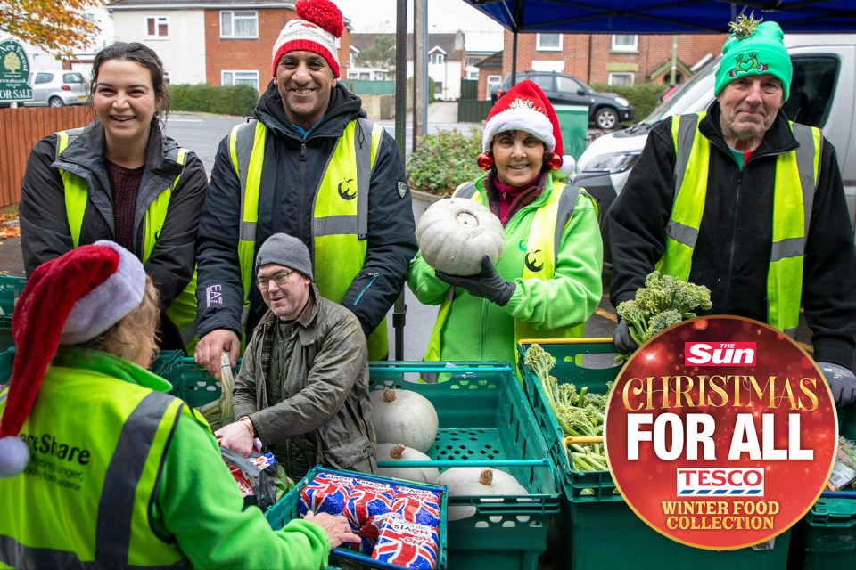 Volunteers wearing Christmas hats and high-visibility vests organize food donations.