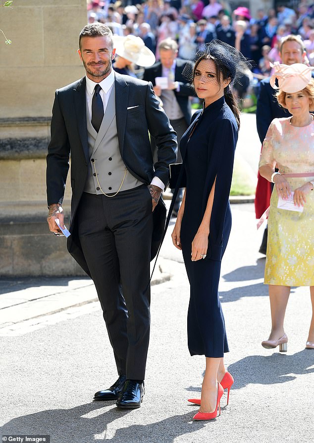 The Daily Mail can reveal that Victoria Beckham has made her husband the suit which he will wear as he is honoured for his services to sport and charity. Pictured: David Beckham and Victoria Beckham arrive at St George's Chapel at Windsor Castle before the wedding of Prince Harry to Meghan Markle on May 19, 2018