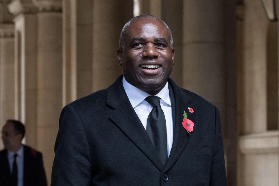 David Lammy, Deputy Prime Minister, Lord Chancellor and Secretary of State for Justice, smiling while walking through Downing Street with a poppy pinned to his lapel.