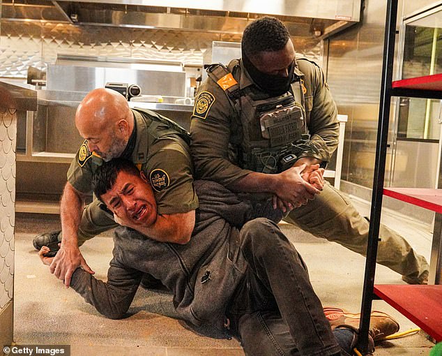 A bloodied migrant is seen being arrested in The Queen City on Wednesday as part of the federal agency's task force called Operation Charlotte's Web