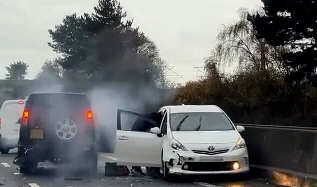 Terrifying moment hooded thugs are filmed 'robbing' driver in crashed Toyota Prius on motorway: Four men arrested