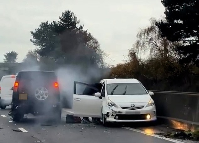 Terrifying moment hooded thugs are filmed 'robbing' driver in crashed Toyota Prius on motorway: Four men arrested