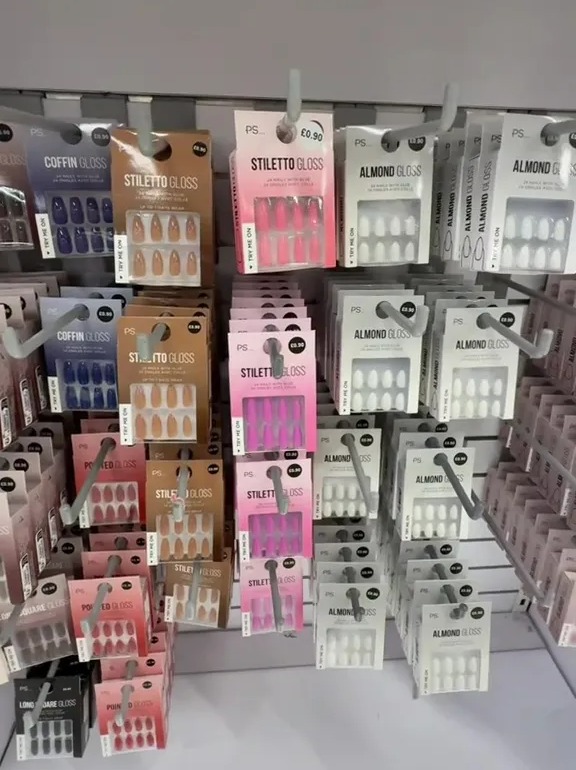 Display of various press-on nails in different colors and shapes, including coffin, stiletto, almond, pointed, and square.