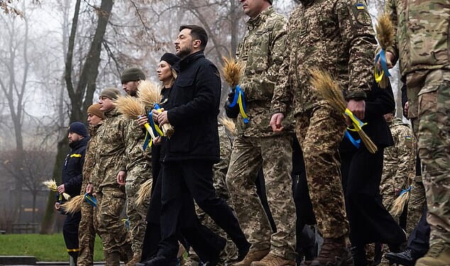 Ukraine's President Volodymyr Zelensky (pictured in black) with Ukrainian soldiers paying tribute to the victims of the famine of 1932-1933 at the National Museum of the Holodomor-Genocide in Kyiv