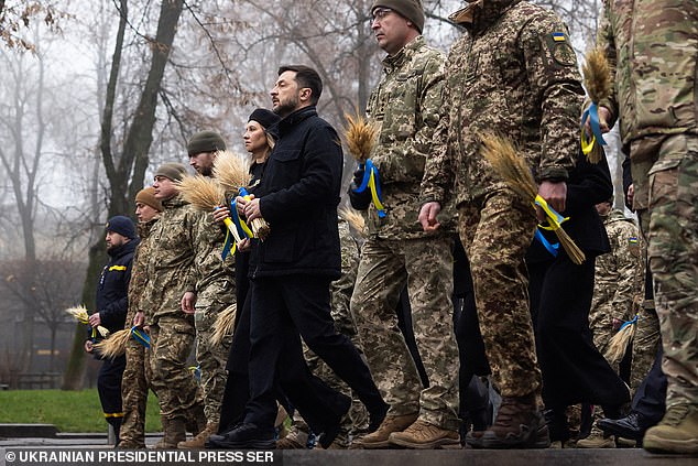 Ukraine's President Volodymyr Zelensky (pictured in black) with Ukrainian soldiers paying tribute to the victims of the famine of 1932-1933 at the National Museum of the Holodomor-Genocide in Kyiv