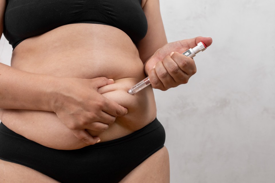 Woman injecting herself in the stomach with a semaglutide needle.